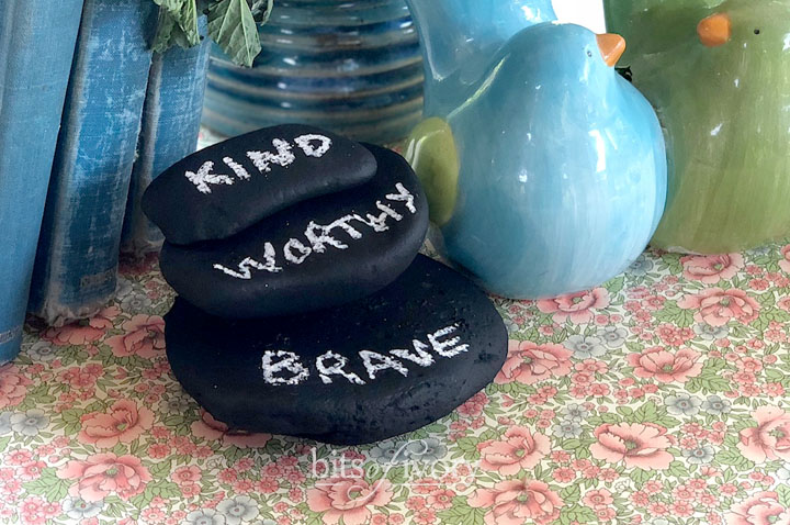 Rocks painted with chalkboard paint with the words kind, worthy, and brave written on them