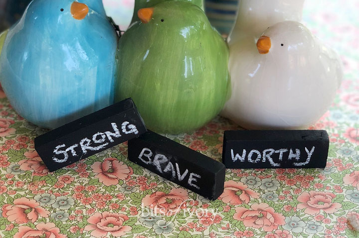 Upcycled game pieces create little chalkboards with strong, brave, and worthy written on them